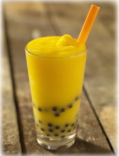 an orange drink in a glass with a straw