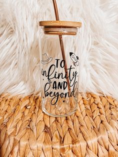 a glass jar with a straw sticking out of it sitting on top of a wicker table