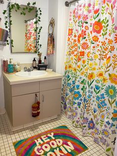 a bathroom with colorful shower curtains and rugs on the floor next to the sink