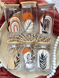 four glass jars with different designs on them