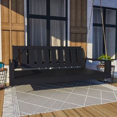 a wooden bench sitting on top of a porch next to a window and potted plants