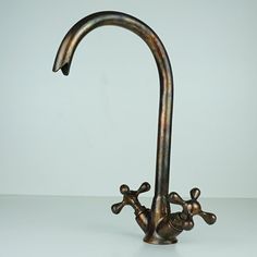 a metal faucet with two spouting holes on the side and one hole in the middle