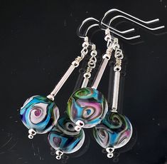 Cosmic Swirl Lampwork Earrings, where celestial beauty meets handcrafted elegance. Meticulously designed with swirling hues, these earrings are a wearable piece of art that captures the mesmerizing allure of the universe. 💫 Celestial Elegance: Embrace the wonder of the cosmos with these one off lampwork earrings. The swirling design evokes the dynamic energy of galaxies and nebulae, adding a touch of mystic charm to your ensemble. 🎨 Handcrafted  Each bead is meticulously handcrafted each with care, ensuring that you receive a unique and high-quality piece of wearable art. The lampwork technique used in the creation of these earrings adds an extra layer of authenticity to their cosmic allure. 🌟 Versatile Wearability: These Cosmic Swirl Lampwork Earrings are perfect for both casual and sp Adjustable Drop Earrings With Artistic Design, Handmade Swirl Earrings As Gift, Handmade Swirl Earrings For Gifts, Adjustable Fusion Style Drop Earrings, Unique Swirl Earrings As Gift, Unique Swirl Earrings For Gifts, Multicolor Glass Drop Earrings, Whimsical Czech Glass Drop Earrings, Lampwork Earring