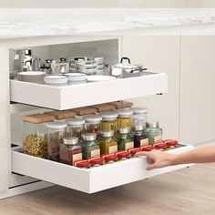 the drawers are open to show spices and condiments in jars, bowls and pans