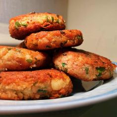 a white plate topped with meat patties on top of a blue and white plate