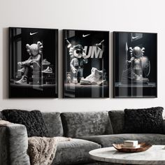 three black and white pictures hang on the wall above a couch in a living room