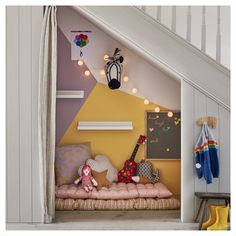 a child's bedroom with yellow walls, white stairs and colorful accessories on the bed