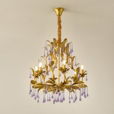 a gold chandelier with purple glass drops hanging from it's center point