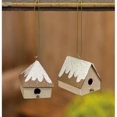 two birdhouses hanging from chains with snow covered tops and white wings on the roof