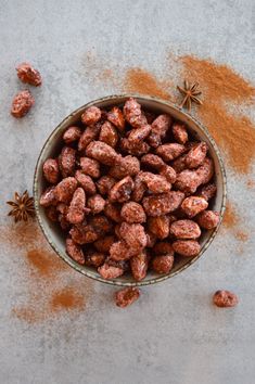 a bowl filled with powdered almonds next to anisette on a table