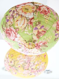 three paper lanterns are stacked on top of each other, with flowers all over them