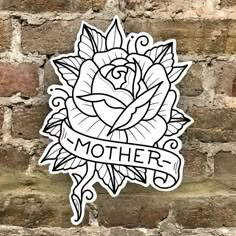 a sticker with the words mother and a rose on it in front of a brick wall