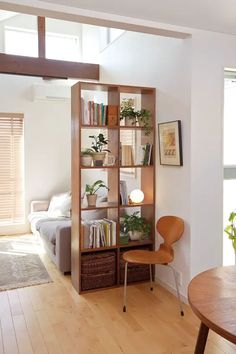 a living room filled with furniture and a wooden table in front of a book shelf