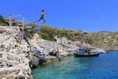 a man jumping into the water from a boat