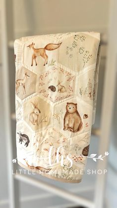 a baby blanket hanging from the side of a chair with pictures of animals on it