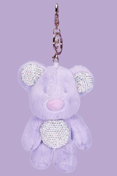 a purple teddy bear keychain hanging from a chain on a purple background,