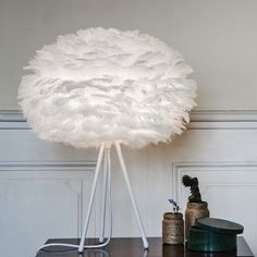 a white lamp sitting on top of a wooden table