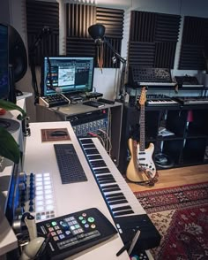 a recording studio with musical instruments and sound equipment on the desk, along with an electric guitar