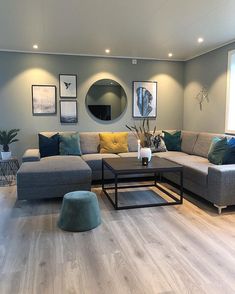 a living room filled with lots of furniture and pictures hanging on the wall above it