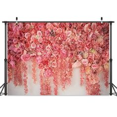 an image of pink flowers hanging on the wall in front of a white backdrop with black stand