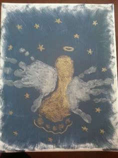 an artistic painting with gold and silver paint on blue paper that looks like two angels in the sky