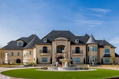 a large house with a fountain in front of it