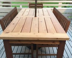 a wooden table with benches on top of it in the middle of a deck area