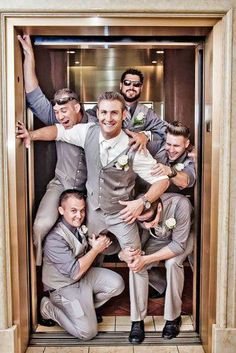 a group of men in suits and ties posing for a photo inside an elevator with their arms around each other