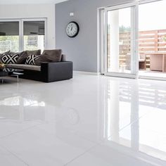 a living room with white floors and large windows