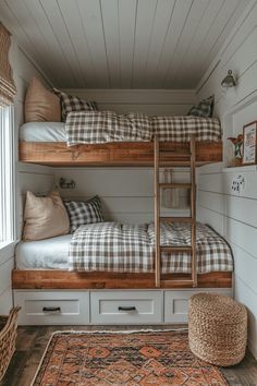 two bunk beds in a small room with white walls and wood flooring on the side