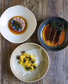 three different types of food in bowls on a wooden table