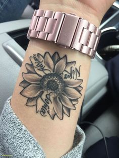 a woman's wrist with a sunflower tattoo on it