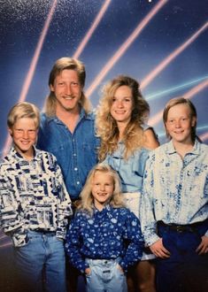 the family is posing for a photo in their 80s's style clothing and jeans