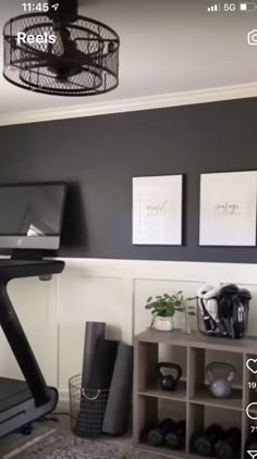 a room with a treadmill and some pictures hanging on the wall above it,