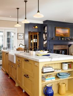 a large kitchen with blue cabinets and white counter tops, along with an island in the middle