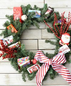 a christmas wreath with candy, candies and other holiday treats on it sitting on a wooden surface