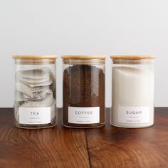 three jars filled with different types of food on top of a wooden table next to each other