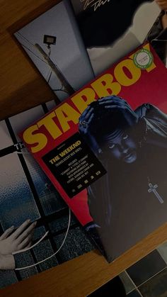 various album covers sitting on top of a wooden table