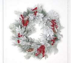 a christmas wreath with red berries and pine cones on white background, ready to be hung