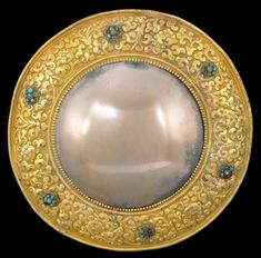 an ornately decorated gold plate with blue stones