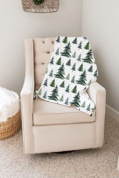 a chair with a blanket on top of it in front of a christmas tree wall hanging