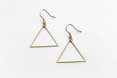 "Lightweight, geometric triangle earrings perfect for your next day out in the summer sunshine. ▲ Brass triangles measure approx. 1 1/4\" ▲ Gold-plated surgical steel earring hooks (hypoallergenic) We try to display product colors as close to life as possible. However, all monitors are different and so there might be slight color variations from screen to screen. CARE INSTRUCTIONS Jewelry should be kept away from moisture as much as possible. Remember to take your jewelry off before swimming and Minimalist Triangle Jewelry For Pierced Ears, Minimalist Triangle Jewelry, Minimalist Earrings For Summer, Everyday Summer Brass Earrings, Minimalist Earrings As Summer Gift, Minimalist Metal Earrings For Summer, Minimalist Earrings For Summer Gift, Everyday Summer Brass Jewelry, Minimalist Summer Earrings With Ear Wire