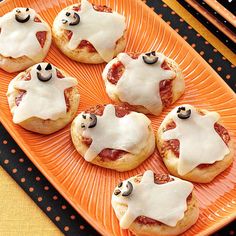 there are many small pizzas with white icing on them and panda bears in the middle