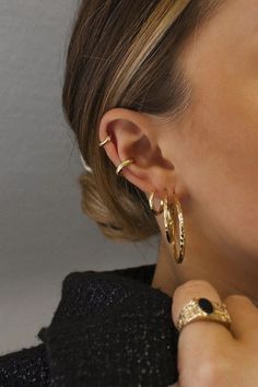 a close up of a person wearing some kind of gold earring on their left ear