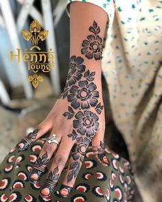 a woman's hand with henna tattoos on it