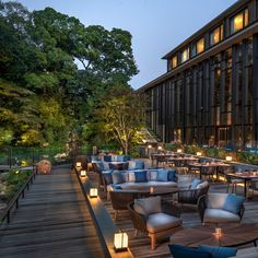 an outdoor restaurant is lit up at night with candles on the tables and chairs outside