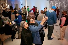 two women taking a selfie in front of a group of people at an event