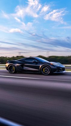 a black sports car driving down the highway