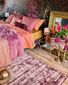 a bedroom with pink and purple decor on the walls, rugs and bedding