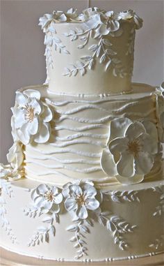 a wedding cake with white frosting and flowers